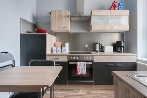 a kitchen with a stove top oven next to a table at Ferienwohnung Residenz bis 6 Gäste , Ferienwohnung Dresden bis 4 Gäste, Ferienwohnung Elbflorenz bis 2 Gäste in Dresden