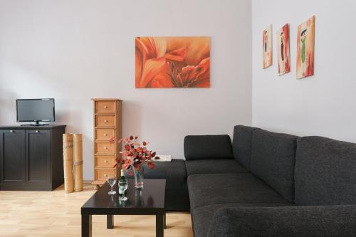 a living room with a couch and a table with flowers at Ferienwohnung Residenz bis 6 Gäste , Ferienwohnung Dresden bis 4 Gäste, Ferienwohnung Elbflorenz bis 2 Gäste in Dresden