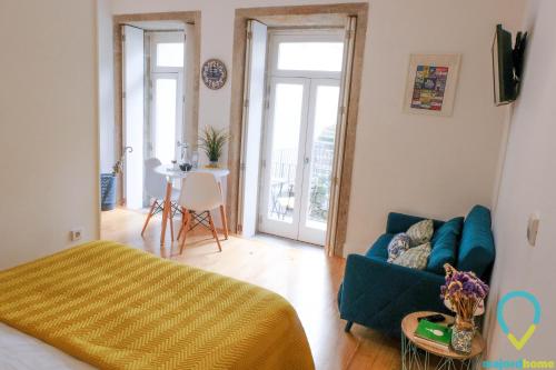 ein Wohnzimmer mit einem blauen Sofa und einem Tisch in der Unterkunft Lovely Porto in Porto