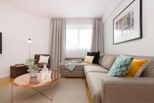 a living room with a couch and a table at RAFAEL KAISER - Premium Apartments City Centre - Contactless Check-In in Vienna