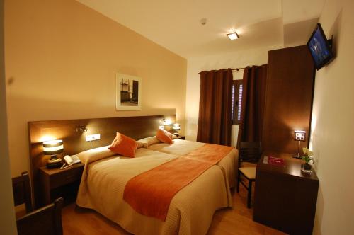 a hotel room with a bed and a television at Hotel Hospederia San Francisco in Priego de Córdoba