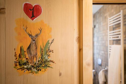 a painting of a deer on a wall with a heart at Hotel Sogni D'Oro in Camporosso in Valcanale
