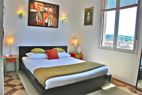 カルカソンヌにあるMistral Apartmentのベッドルーム1室(大型ベッド1台、窓2つ付)