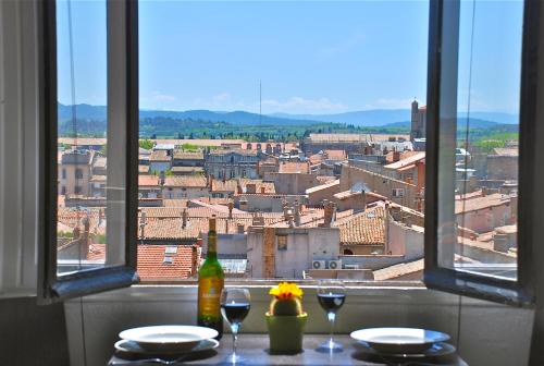 una mesa con vistas a la ciudad desde una ventana en Appartement Mistral vue imprenable, en Carcassonne