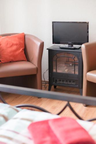 a living room with two chairs and a television at Ferienwohnung Residenz bis 6 Gäste , Ferienwohnung Dresden bis 4 Gäste, Ferienwohnung Elbflorenz bis 2 Gäste in Dresden