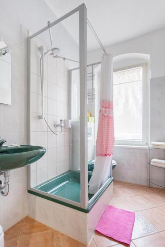 a bathroom with a tub with a shower and a sink at Ferienwohnung Residenz bis 6 Gäste , Ferienwohnung Dresden bis 4 Gäste, Ferienwohnung Elbflorenz bis 2 Gäste in Dresden