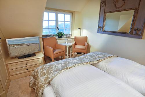 Schlafzimmer mit einem Bett und einem Flachbild-TV in der Unterkunft Ferienwohnung Dikstig in Kampen