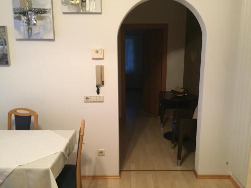 a hallway leading to a room with a bed and a table at Lochererhof in Appiano sulla Strada del Vino