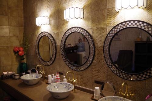 a bathroom with three sinks and three mirrors at Ryoso Chatani in Kyoto
