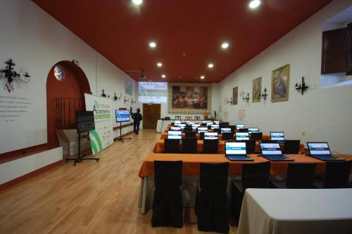 a room with several tables with laptops on them at Hotel Hospederia San Francisco in Priego de Córdoba