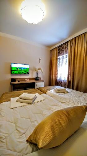 a large white bed in a bedroom with a tv at Hotel Soldo in Međugorje