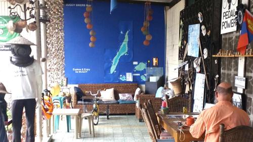 a man sitting at a table in a room at Bugoy Bikers Hostel in Cebu City