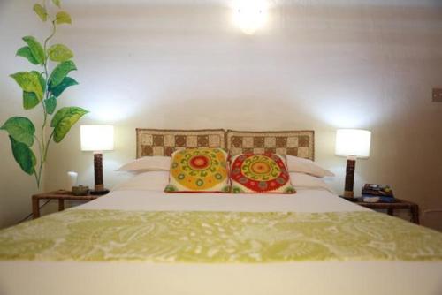 a bedroom with a white bed with two lamps at Da Fabio in Negril