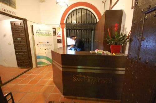 un hombre sentado en un mostrador en un edificio en Hotel Hospederia San Francisco, en Priego de Córdoba