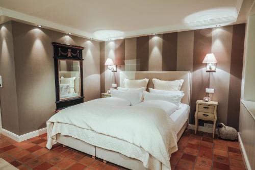 ein Schlafzimmer mit einem großen weißen Bett und einem Spiegel in der Unterkunft Ferienwohnung Sönshörn in Munkmarsch