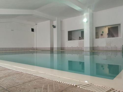 uma piscina com água azul num edifício em Hotel Kristall em San Massimo