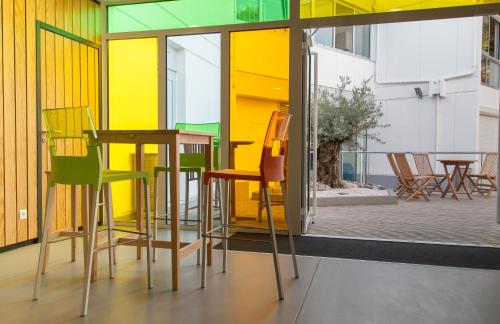 une chambre avec des chaises jaunes et vertes et une table dans l'établissement Auberge de Jeunesse, à La Rochelle