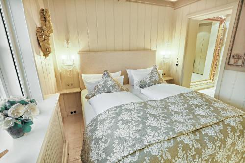 1 dormitorio con 1 cama grande y espejo en Ferienwohnung Liiger Wal, en Morsum