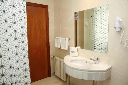 y baño con lavabo y espejo. en Hotel Alda Lalín, en Lalín