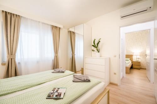 ブダペストにあるThe Lion's Loft Apartment - 4BR & 3BA - Terrace - ACの白いベッドルーム(ベッド1台、鏡付)