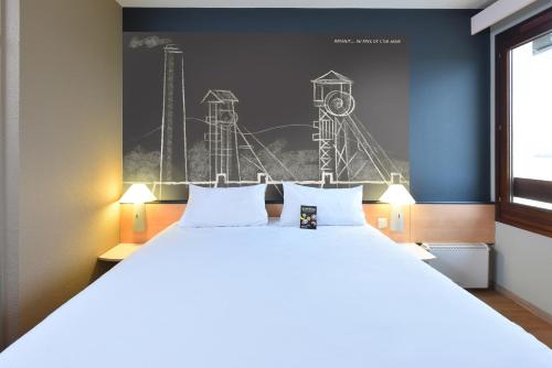 a bedroom with a large bed and a mural of a roller coaster at ibis Charleroi Airport Brussels South in Charleroi