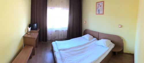 Motel Topolog في رمينكو فيلتشا: غرفة نوم بسرير وملاءات بيضاء ونافذة
