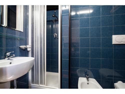 ローマにあるPrefetti suitteの青いタイル張りのバスルーム(洗面台、トイレ付)