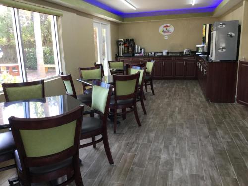 a dining room with tables and chairs in a restaurant at Super 8 by Wyndham Sarasota Near Siesta Key in Sarasota