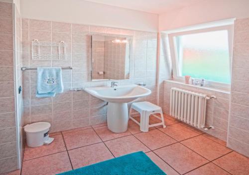 a bathroom with a sink and a toilet and a window at Residence Corte Delle Rose in Garda