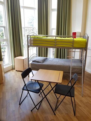 ロンドンにあるBelsize House (Belsize Park)の二段ベッド1組、椅子、テーブルが備わる客室です。
