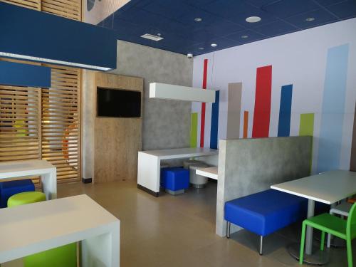 a dining room with tables and chairs and a tv at ibis budget Sorocaba in Sorocaba