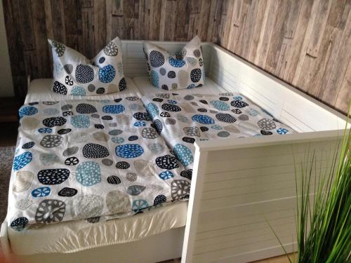ein Bett mit blauen und weißen Kissen darauf in der Unterkunft Ferienwohnung Hecht in Leipzig