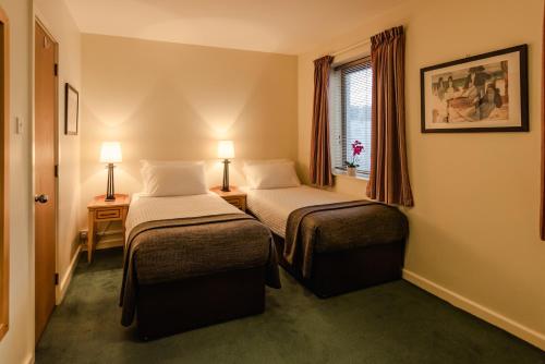 ダブリンにあるDCU ルームズ グラスネヴィン キャンパス アコモデーションのベッド2台と窓が備わるホテルルームです。