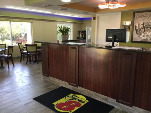a bar in a restaurant with a table and chairs at Super 8 by Wyndham Sarasota Near Siesta Key in Sarasota