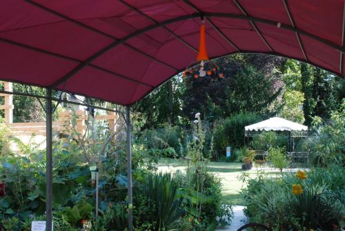 a red umbrella in a garden with plants at La Gourmandine in Châtellerault