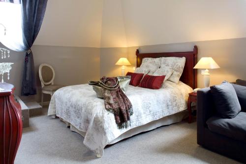 a bedroom with a large bed with red pillows at La Gourmandine in Châtellerault