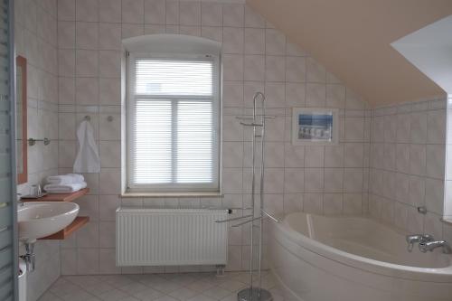 a white bathroom with a tub and a sink at Gästewohnung Elström in Dresden