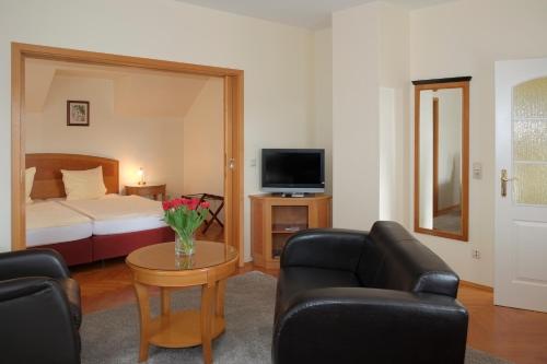 ein Wohnzimmer mit einem Bett, einem Sofa und einem Tisch in der Unterkunft Gästewohnung Elström in Dresden