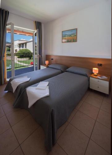 a bedroom with two beds with towels on them at Residence Corte Delle Rose in Garda