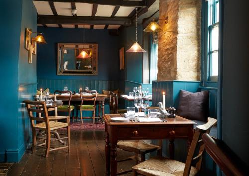 a dining room with a long table and chairs at The Bull Hotel in Fairford