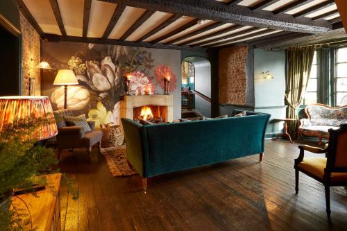 a living room with a couch and a fireplace at The Bull Hotel in Fairford