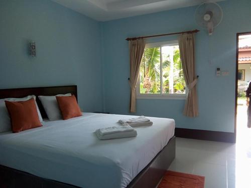 a bedroom with a large bed with a window at Lanta Salamat House in Ko Lanta