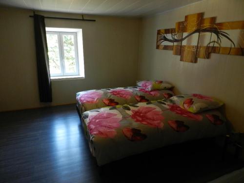 een slaapkamer met een bed met roze bloemen erop bij la maison du parc in Dammarie-sur-Saulx