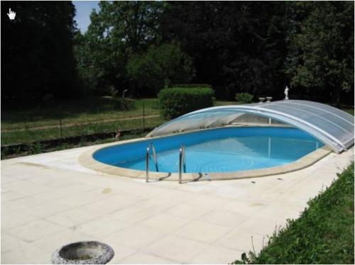 een zwembad met een overkapping bij la maison du parc in Dammarie-sur-Saulx