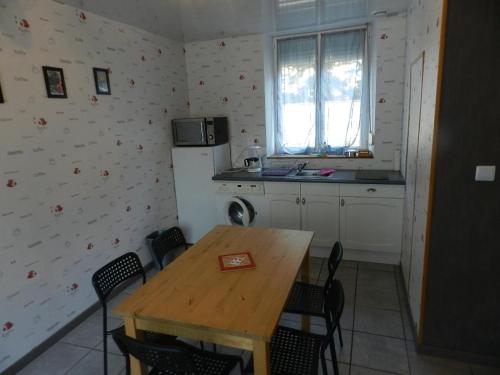 Il comprend une cuisine équipée d'une table, d'un réfrigérateur, d'une table et de chaises. dans l'établissement la maison du parc, à Dammarie-sur-Saulx