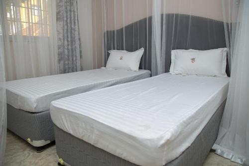 Una cama o camas en una habitación de Villa Karibu Serviced Apartments-Kampala