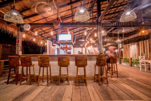a bar with wooden stools in a room at Sara Resort in Koh Rong Sanloem