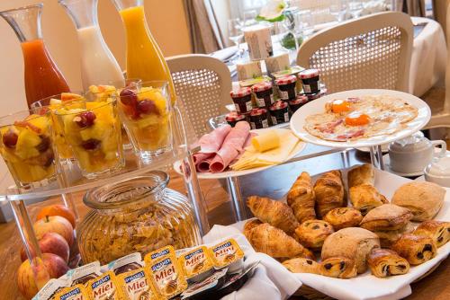 een tafel met borden met gebak en ander voedsel bij Hôtel Château de l'Hermitage in Pontoise