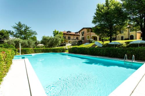 a large blue swimming pool in front of a house at Villa Santa Caterina in Manerba del Garda