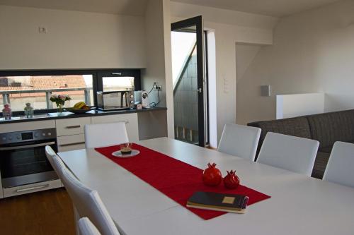 a kitchen with a white table with a red napkin at Hauptbahnhof S2 in Vienna